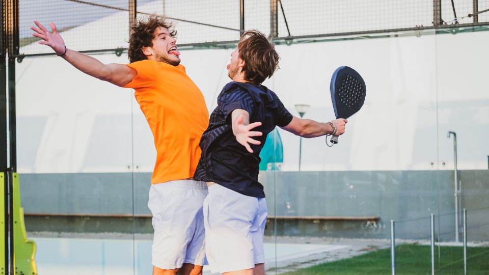 Two padel players chest bumping in celebration